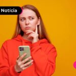 Pessoa de vermelho com celular em mãos