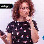 Imagem de jovem com expressão de dúvida segurando um celular.