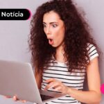Imagem jovem com expressão de surpresa enquanto lê algo no computador.