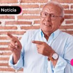 Imagem pessoa de idade com expressão de dúvida apontando com o dedo indicador para o lado.