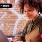 Imagem de jovem sorridente usando computador.