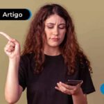 Imagem mostra pessoa jovem com expressão de dúvida segurando um celular.