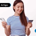 Pessoa com camisa listrada e celular em mãos