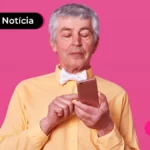 Imagem mostra pessoa de idade mexendo no celular.