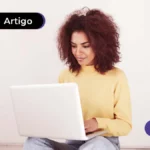 Imagem de jovem feliz mexendo no computador.