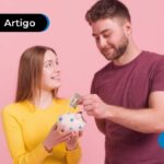 Casal sorrindo segurando um cofrinho e dinheiro.
