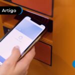 Imagem mostra mão segurando celular.