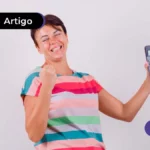 Imagem mostra pessoa sorrindo e segurando celular.