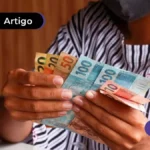 Imagem de mulher segurando notas de reais ilustrando o recebimento do saque-aniversário.