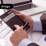 Imagem mostra pessoa usando uma calculadora.
