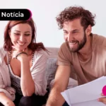 imagem de duas pessoas felizes com papéis na mão