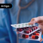Imagem mostra mão segurando vários medicamentos.