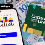 app bolsa família no celular e cédulas de 100 reais no fundo