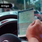 Pessoa dentro do carro segurando a CNH.