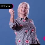 Mulher branca sorrindo e levantando um braço para o alto