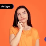 Jovem vestindo blusa laranja com expressão de dúvida e mão no queixo.