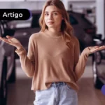 Pessoa com os braços abertos a frente de vários carros