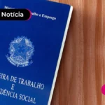 Carteira de trabalho física sob uma superfície de madeira.