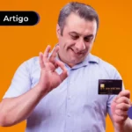Pessoa sorrindo segurando um cartão de crédito.