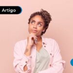 Jovem com expressão de dúvida e mão no queixo.