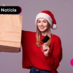 Jovem sorrindo vestindo blusa de frio vermelha e segurando sacola.