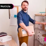 Pessoa em uma sala com estantes segurando uma caixa.