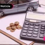 Papel, moedas, calculadora e um carro em miniatura sobre uma mesa.