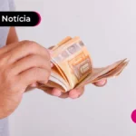 Mão segurando notas de dinheiro.