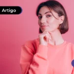 Pessoa com camisa de manga longa rosa com uma mão no queixo como se estivesse pensando