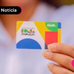 Pessoa segurando o cartão do Bolsa família em foco na imagem.