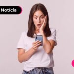 Pessoa jovem olhando para o celular com expressão espantada.