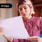 Pessoa segurando um papel com um olhar confuso
