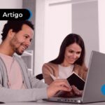 Duas pessoas sorrindo olhando para o computador