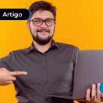 Pessoa sorrindo segurando um computador e apontando para ele