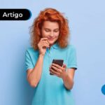 Imagem mostra jovem sorrindo olhando para o celular.