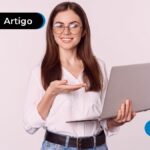 Pessoa sorrindo segurando um computador
