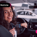 Pessoa sorrindo com a mão no volante