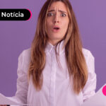 Pessoa com expressão assustada segurando papéis nas duas mãos.