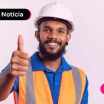 Imagem mostra trabalhador sorrindo fazendo sinal de joinha com as mãos.
