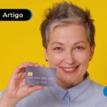 Pessoa sorrindo segurando um cartão