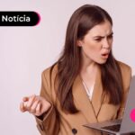 Jovem com expressão de dúvida olhando para tela de computador.