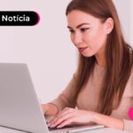 Jovem concentrada digitando em teclado de notebook.