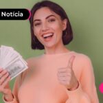 Jovem sorrindo segurando notas de dinheiro.