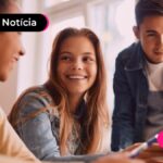Três jovens sorrindo e conversando.