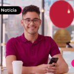 Imagem mostra pessoa jovem sorrindo segurando um celular.