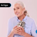 Pessoa de mais idade sorrindo segurando um pote com cédulas de dinheiro