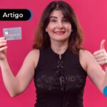 Pessoa sorrindo segurando um cartão