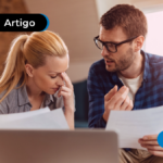Duas pessoas jovens conversando e segurando papéis.