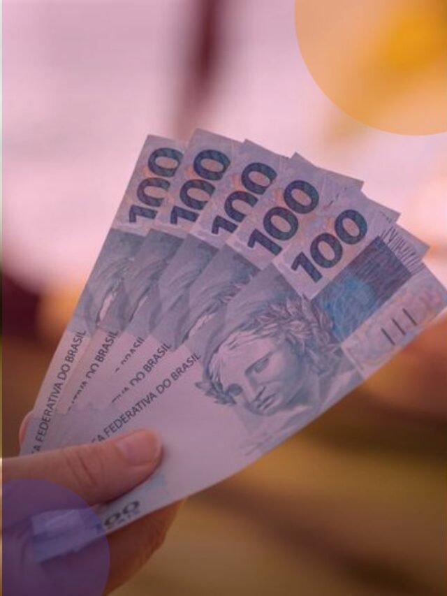 Pessoa segurando cinco notas de cem reais