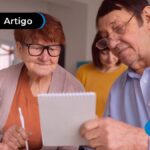 Duas pessoas de idade fazendo contas usando papel e caneta.